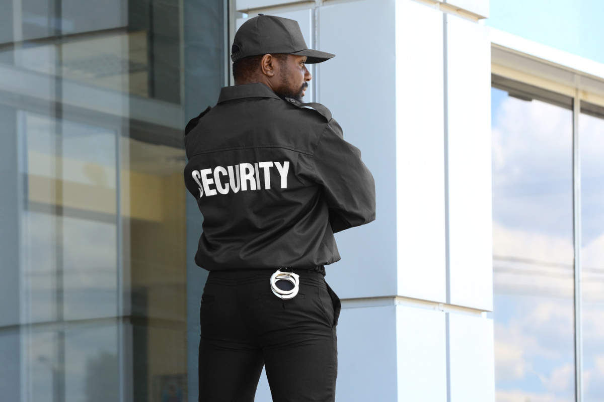 Male security guard standing near building