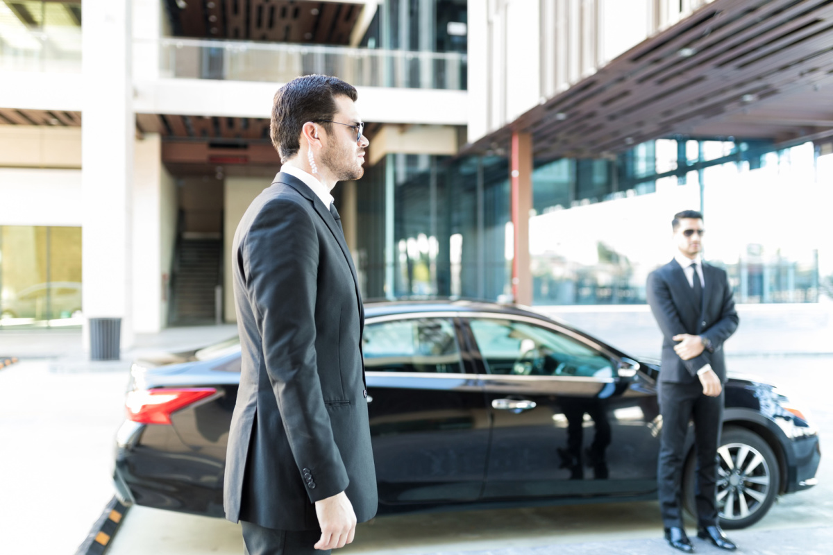 Executive protection agents standing by car